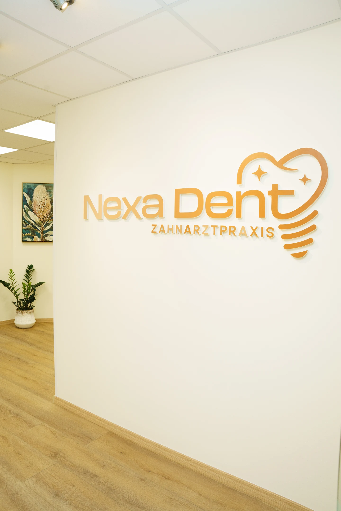 Goldenes Nexa-Dent-Logo an der Praxiswand