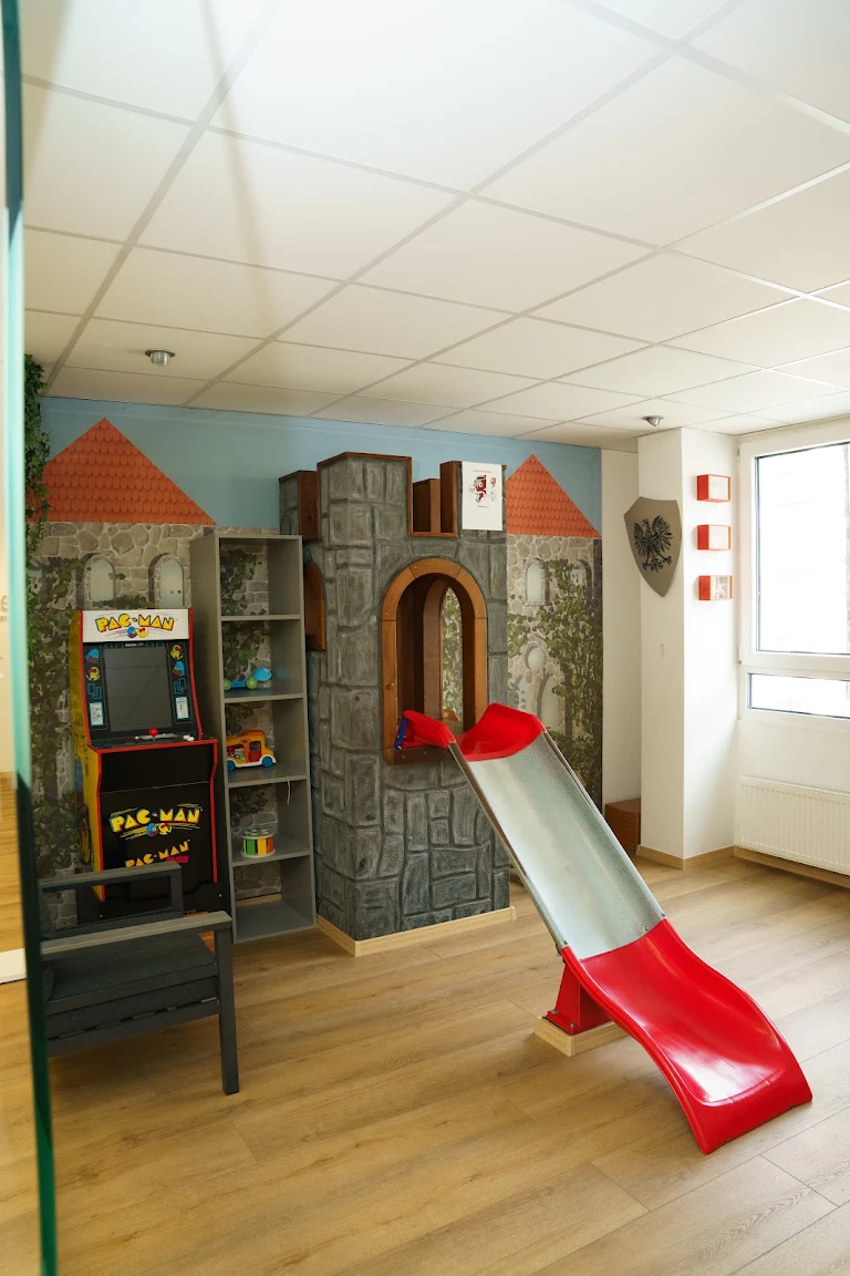 Spielbereich mit Burg, Rutsche und Spielautomat